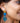 Close-up picture of Francoise gold long statement earrings in turquoise and blue worn by a model. Close-up foto van lange grote gouden oorbellen genaamd Francoise in de kleuren turquoise en blauw gedragen door een model.