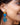 Close-up picture of Francoise gold long statement earrings in turquoise and blue worn by a model. Close-up foto van lange grote gouden oorbellen genaamd Francoise in de kleuren turquoise en blauw gedragen door een model.