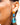 Side view picture of Francoise gold long statement earrings in turquoise and blue worn by a model. Zijaanzichtfoto van lange grote gouden oorbellen genaamd Francoise in de kleuren turquoise en blauw gedragen door een model.