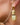 Detail picture of Celeste: champagne colored gold earrings worn on a model. Detailfoto van Celeste: champagnekleurige gouden oorbellen gedragen door een model.