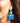 Close-up picture of square turquoise and petrol blue Esmee statement earrings worn on model. Close-up foto van grote vierkante turquoise en petrol blauwe Esmee oorbellen gedragen door een model.