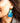 Close-up picture of square turquoise and petrol blue Esmee statement earrings worn on model. Close-up foto van grote vierkante turquoise en petrol blauwe Esmee oorbellen gedragen door een model.