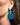 Close-up picture of square turquoise and petrol blue Esmee statement earrings worn on model. Close-up foto van grote vierkante turquoise en petrol blauwe Esmee oorbellen gedragen door een model.