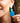 Close-up picture of square turquoise and petrol blue Esmee statement earrings worn on model. Close-up foto van grote vierkante turquoise en petrol blauwe Esmee oorbellen gedragen door een model.