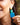 Close-up picture of square turquoise and petrol blue Esmee statement earrings worn on model. Close-up foto van grote vierkante turquoise en petrol blauwe Esmee oorbellen gedragen door een model.